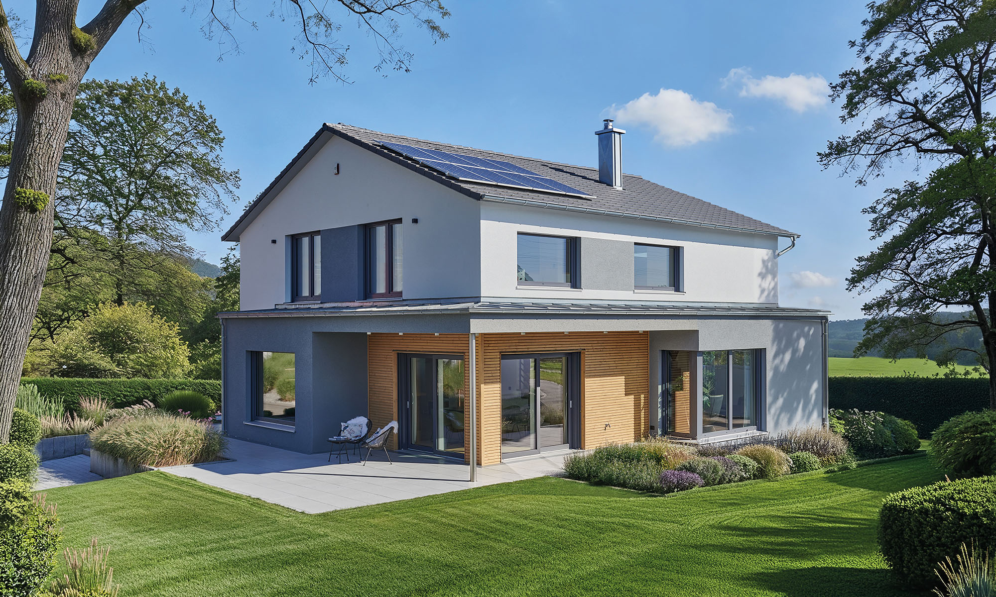 Zweigeschossiges Haus in Weiß-, Grau- und Holztönen mit Solaranlage, überdachter Terrasse, großen Fensterflächen und weitläufigem Garten.